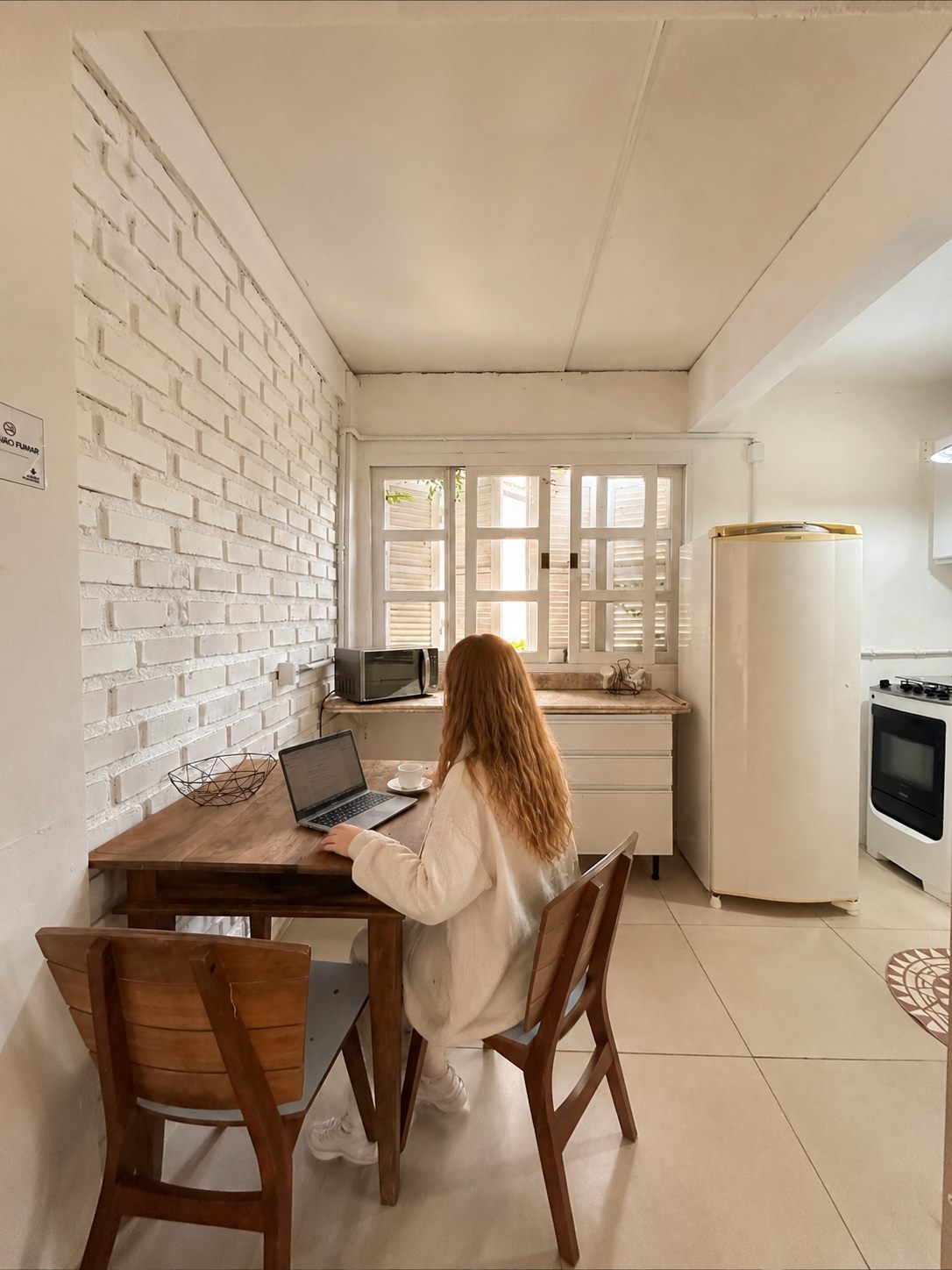 Cozinha do apartamento, com mesa de trabalho, geladeira e fogão próprios