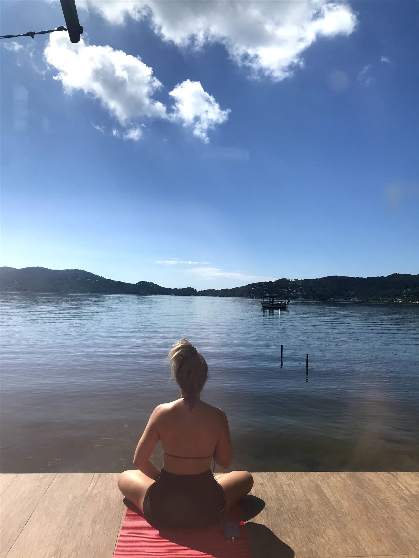 Meditação pela manhã no deck, de frente para a lagoa calma e os morros
